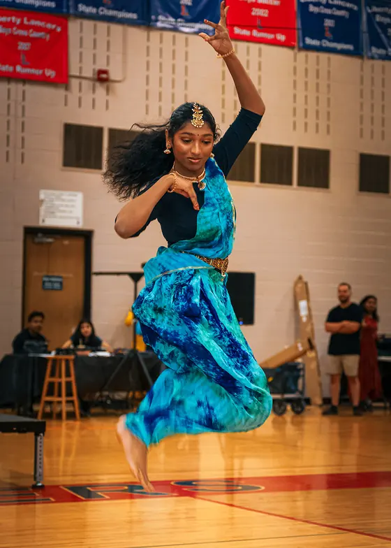 A dancer performing a classical solo in a blue and turquoise costume