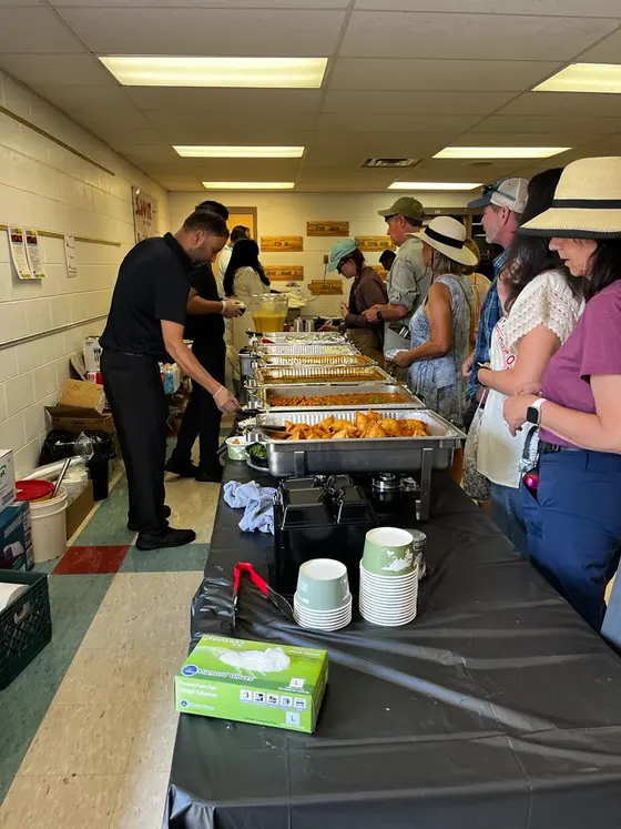 Volunteers serving guests along the buffet line