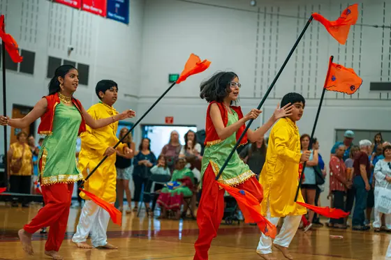 Young performers dancing with orange flags