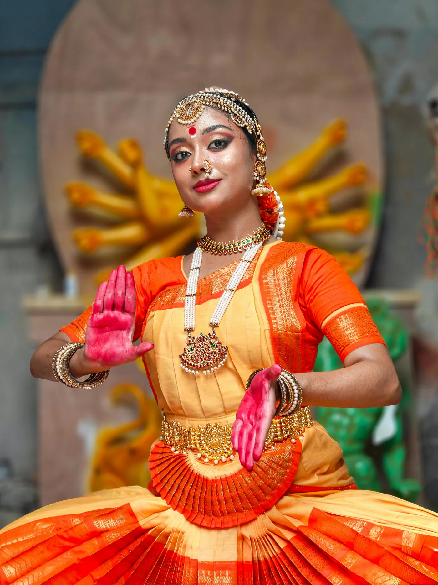 A classical dancer in an orange and gold costume